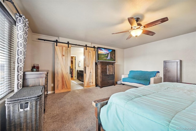 12766 Sunlight Peak Pl, Peyton, CO 80831 - carpeted bedroom with a barn door, baseboards, ceiling fan, and ensuite bath