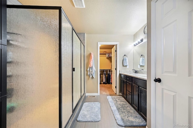 12766 Sunlight Peak Pl, Peyton, CO 80831 - full bath with a stall shower, wood finished floors, vanity, a spacious closet, and baseboards