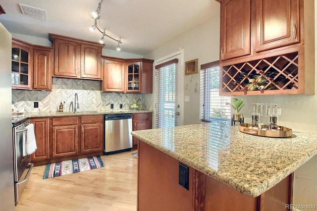3835 Pecos St, Denver, CO 80211 - kitchen with stainless steel dishwasher, a sink, stove, light wood finished floors, and light stone countertops