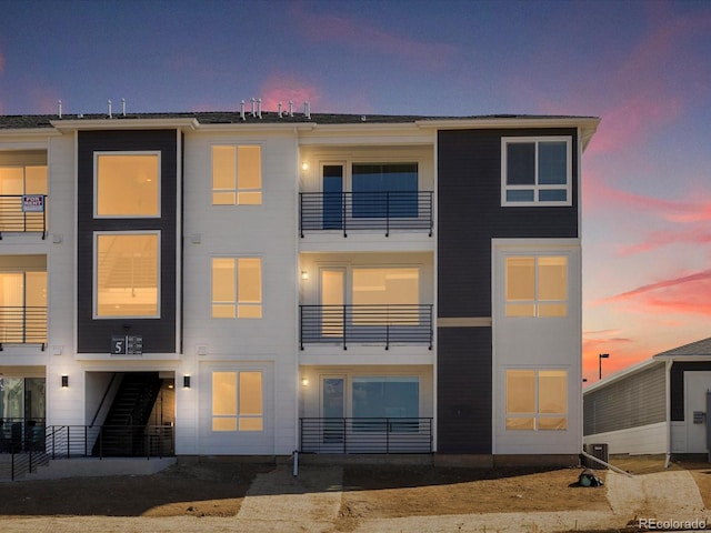 back of house at dusk featuring central air condition unit