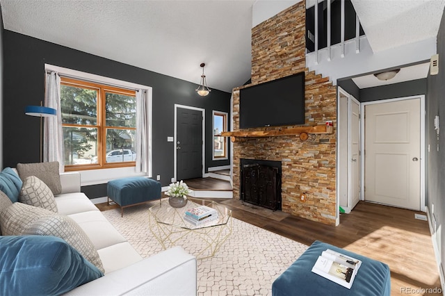 living room with vaulted ceiling, a fireplace, dark hardwood / wood-style flooring, and a textured ceiling