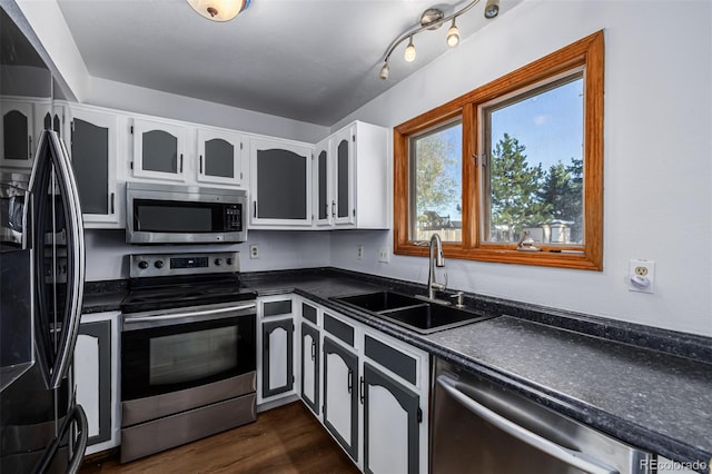 kitchen with white cabinets, appliances with stainless steel finishes, dark wood-type flooring, and sink