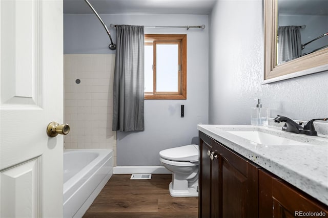 full bathroom featuring wood-type flooring, vanity, toilet, and tiled shower / bath combo