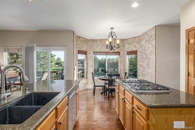 5048 Rocky Mountain Dr, Castle Rock, CO 80109 - kitchen with a sink, stainless steel appliances, wood finished floors, a chandelier, and dark stone counters