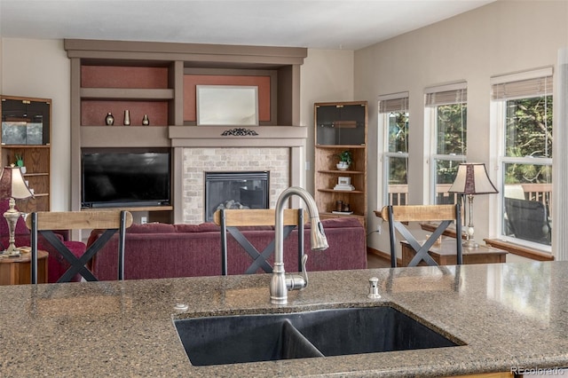 5048 Rocky Mountain Dr, Castle Rock, CO 80109 - kitchen with a sink, stone counters, and a fireplace