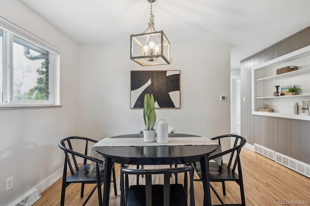 8490 E Davies Pl, Centennial, CO 80112 - dining area with light wood-style floors, a chandelier, and built in shelves
