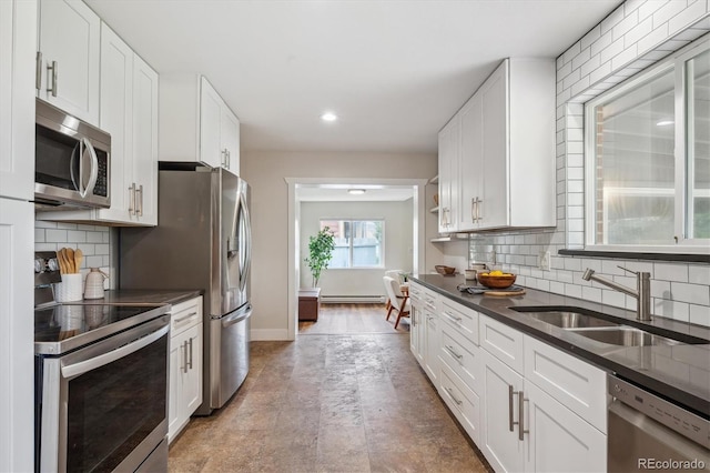 8490 E Davies Pl, Centennial, CO 80112 - kitchen featuring appliances with stainless steel finishes, dark countertops, white cabinets, backsplash, and recessed lighting
