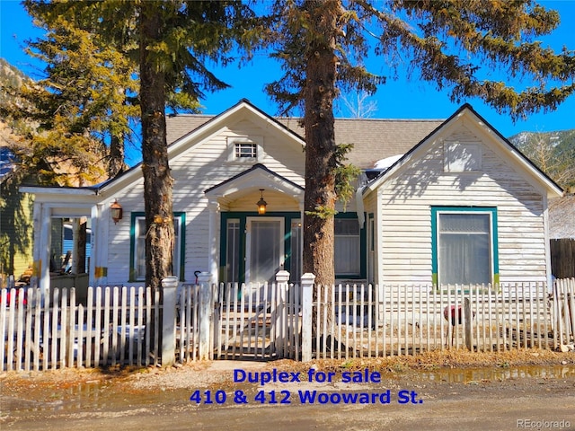 bungalow featuring a fenced front yard and a porch