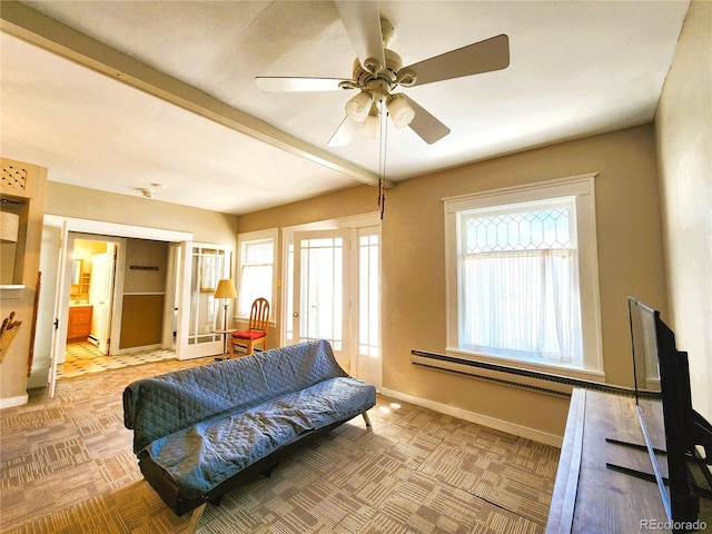 carpeted living area with a baseboard radiator, baseboards, and ceiling fan