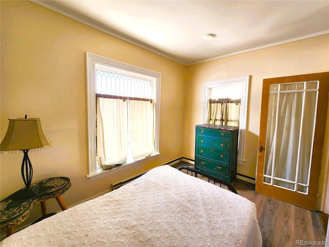 bedroom with baseboard heating and wood finished floors