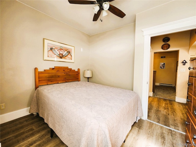 bedroom with baseboard heating, ceiling fan, baseboards, and wood finished floors