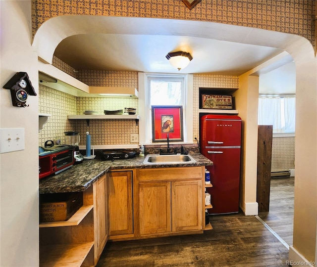 kitchen with dark countertops, a sink, refrigerator, and open shelves