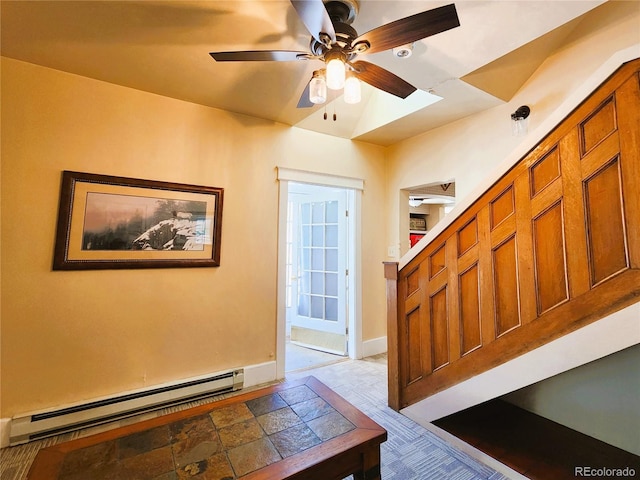 foyer entrance featuring baseboard heating, baseboards, and a ceiling fan