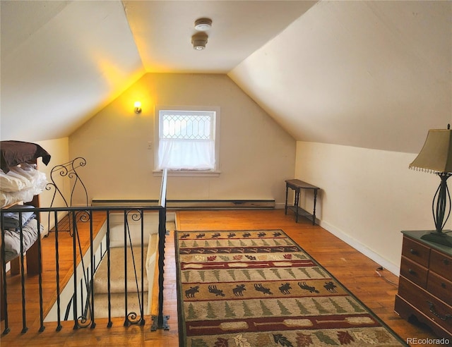 additional living space with baseboards, vaulted ceiling, and hardwood / wood-style flooring