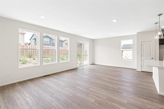 13342 E 110th Way, Commerce City, CO 80022 - unfurnished living room with healthy amount of natural light, wood finished floors, baseboards, and recessed lighting