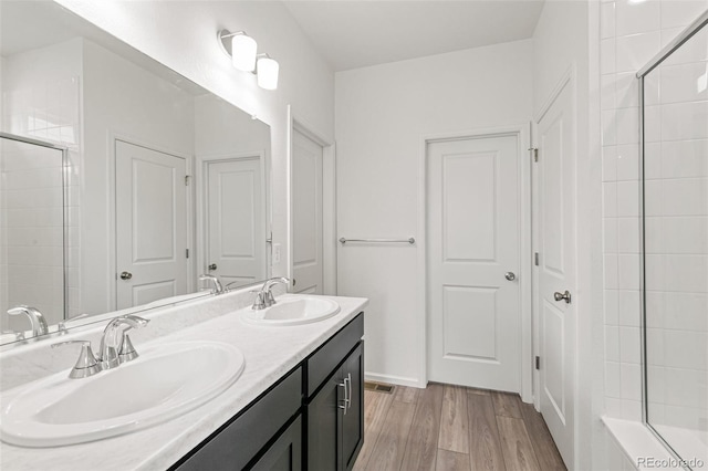 13342 E 110th Way, Commerce City, CO 80022 - full bath featuring tiled shower, double vanity, wood finished floors, and a bath