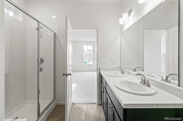 13342 E 110th Way, Commerce City, CO 80022 - bathroom featuring wood finished floors, a stall shower, and double vanity