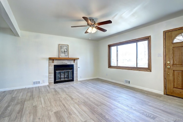 unfurnished living room featuring a wealth of natural light, visible vents, and wood finished floors