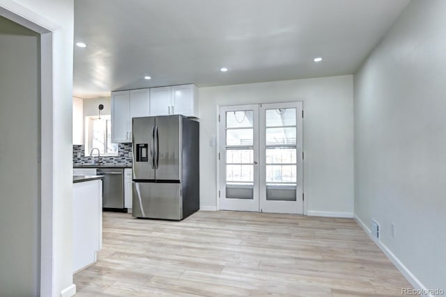 kitchen featuring light wood finished floors, recessed lighting, stainless steel appliances, decorative backsplash, and french doors