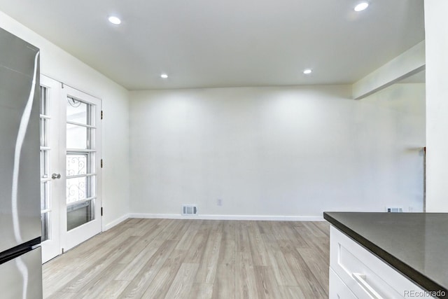 interior space featuring light wood-type flooring, visible vents, baseboards, and recessed lighting