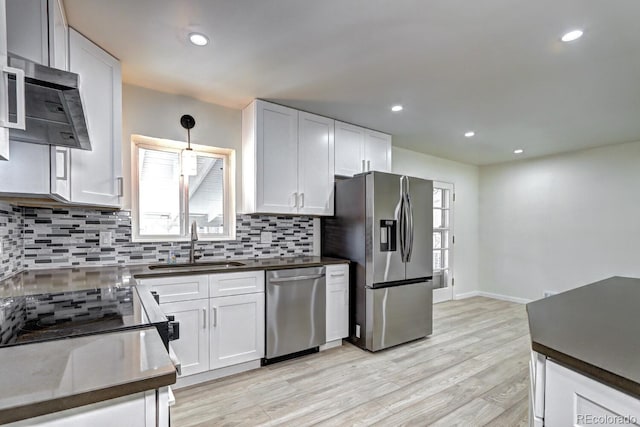 kitchen featuring a sink, stainless steel appliances, a healthy amount of sunlight, and decorative backsplash