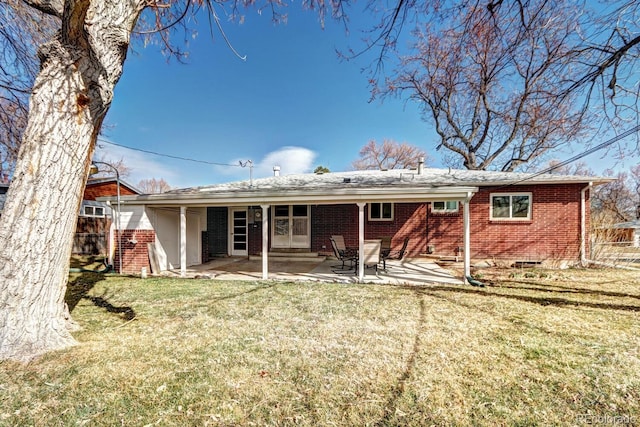 back of house with a patio, a yard, fence, and brick siding