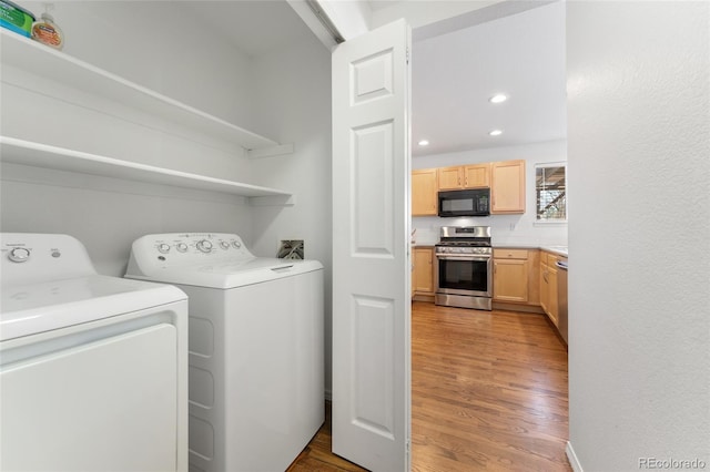 washroom with light hardwood / wood-style floors and independent washer and dryer