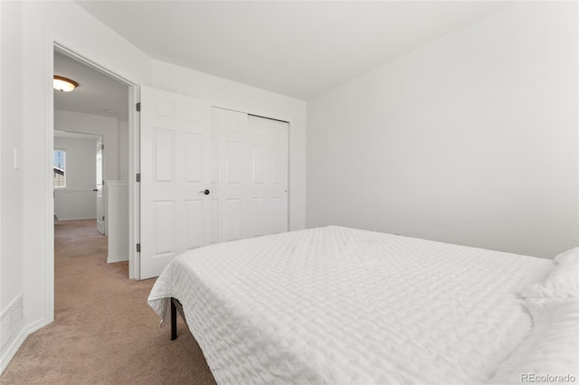 bedroom with light carpet and a closet