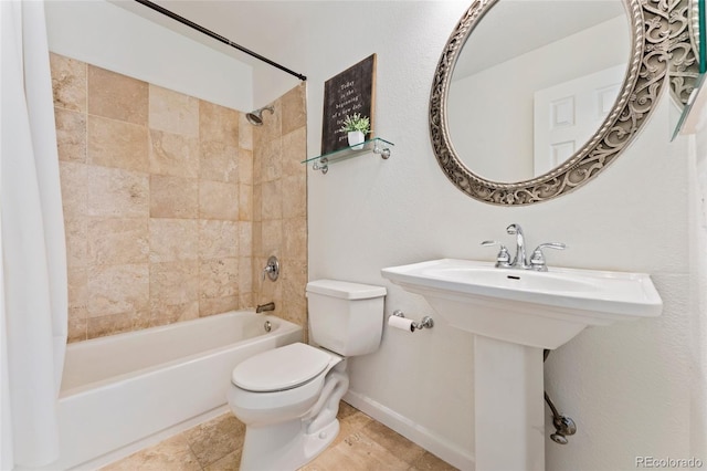 bathroom with tiled shower / bath combo and toilet