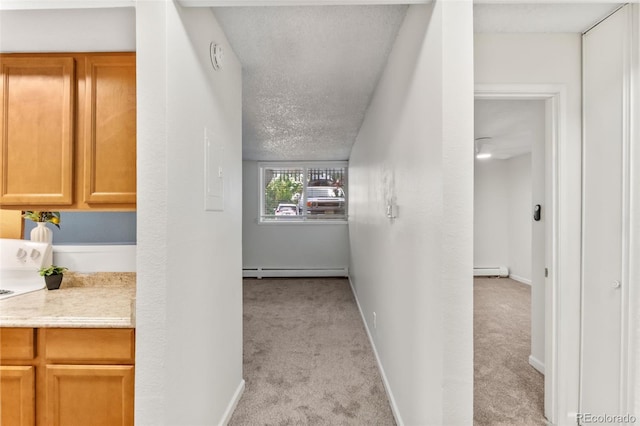 2707 Valmont Rd Unit 106, Boulder, CO 80304 - hallway with baseboard heating, light colored carpet, a baseboard heating unit, and a textured ceiling