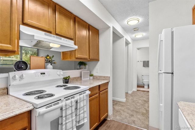 2707 Valmont Rd Unit 106, Boulder, CO 80304 - kitchen featuring white appliances, under cabinet range hood, a textured ceiling, light countertops, and brown cabinetry
