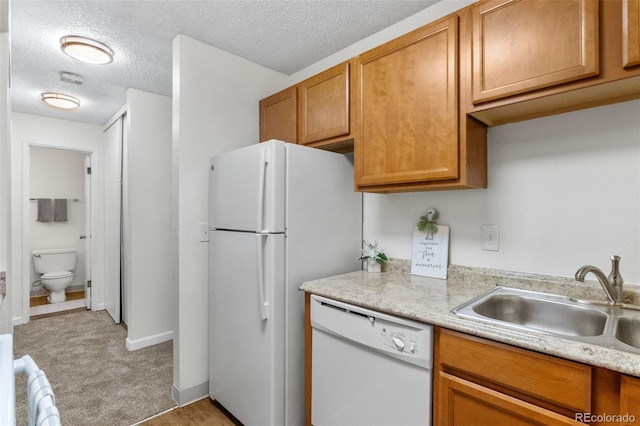 2707 Valmont Rd Unit 106, Boulder, CO 80304 - kitchen featuring white appliances, light countertops, a textured ceiling, brown cabinetry, and light carpet