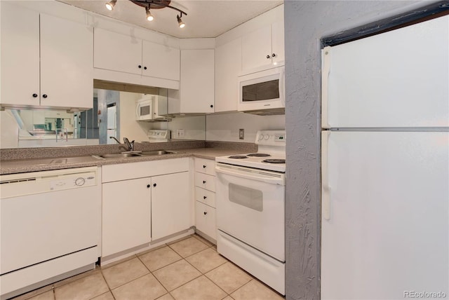 kitchen featuring light tile patterned floors, white appliances, white cabinetry, and sink