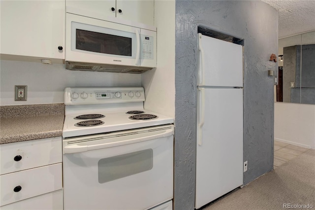 kitchen featuring white cabinets, white appliances, and a textured ceiling