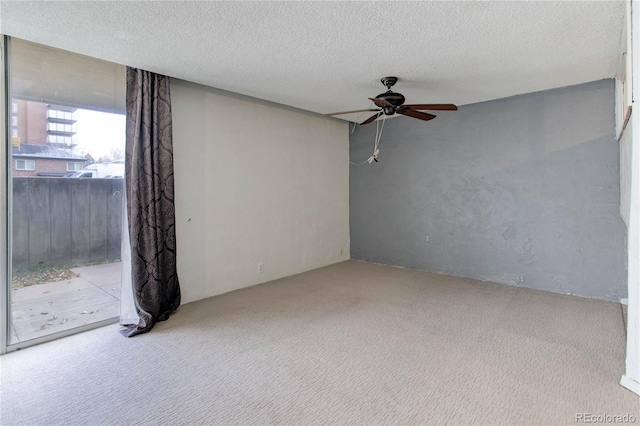 carpeted empty room featuring a textured ceiling and ceiling fan