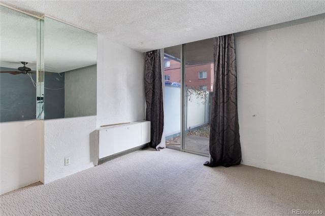 spare room with carpet flooring, a textured ceiling, plenty of natural light, and ceiling fan