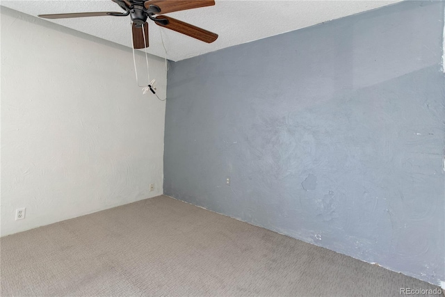 empty room featuring ceiling fan and carpet