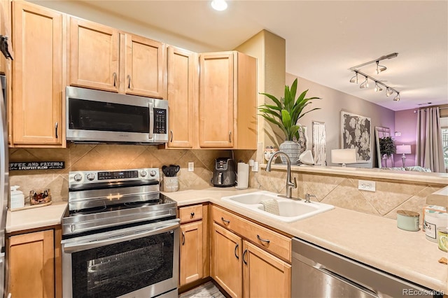 kitchen featuring stainless steel appliances, tasteful backsplash, sink, and light brown cabinets