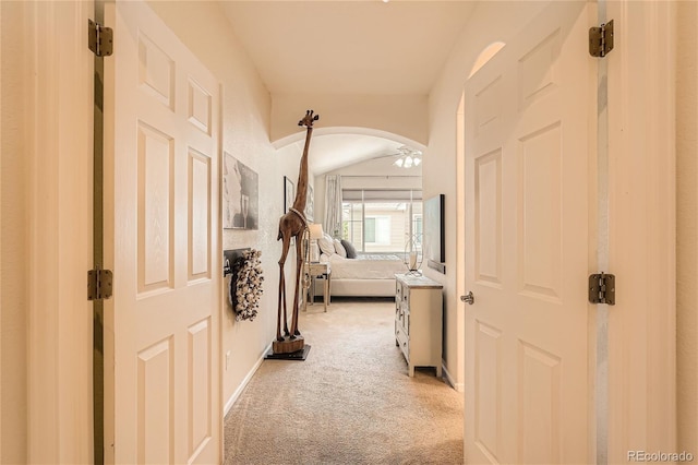 hall with light carpet and vaulted ceiling