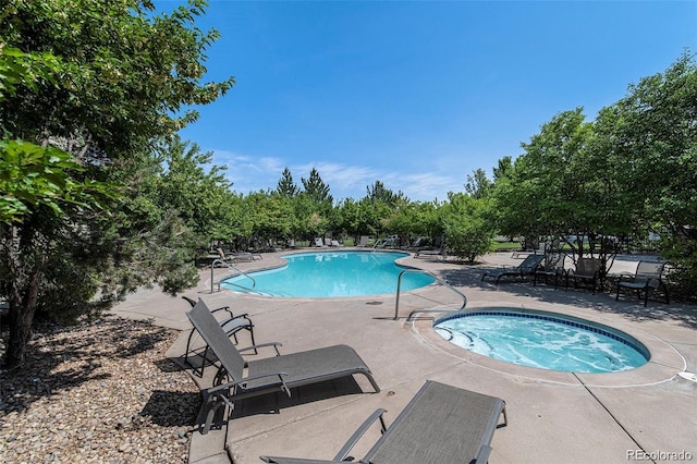 view of swimming pool with a patio area and a community hot tub