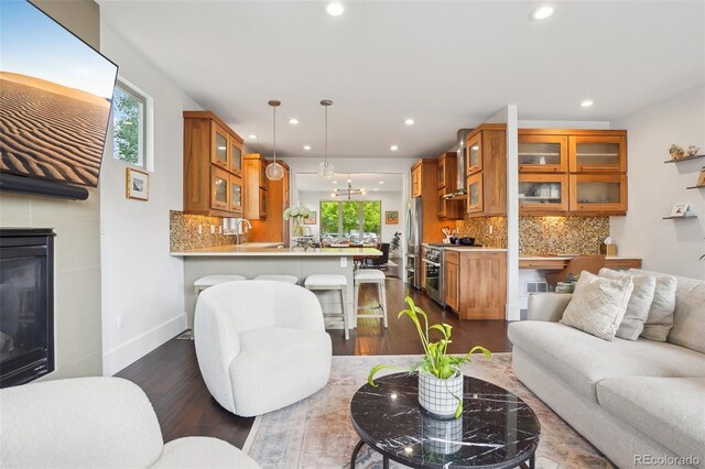 1511 S Pennsylvania St, Denver, CO 80210 - living area featuring recessed lighting, dark wood-style floors, a tiled fireplace, and baseboards