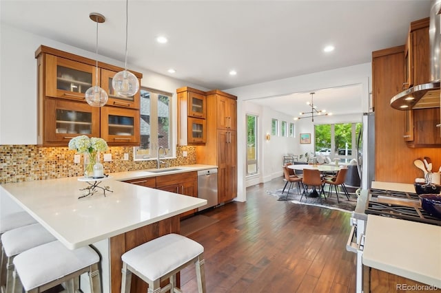 1511 S Pennsylvania St, Denver, CO 80210 - kitchen with appliances with stainless steel finishes, brown cabinets, a sink, decorative backsplash, and a chandelier