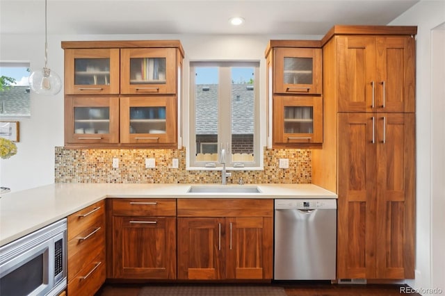 1511 S Pennsylvania St, Denver, CO 80210 - kitchen with appliances with stainless steel finishes, a sink, brown cabinetry, tasteful backsplash, and recessed lighting