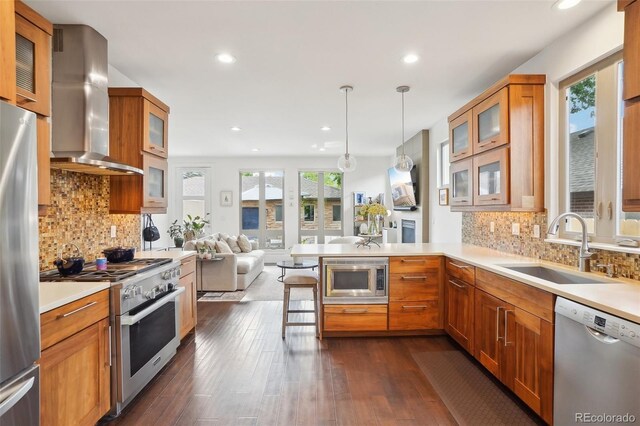 1511 S Pennsylvania St, Denver, CO 80210 - kitchen featuring appliances with stainless steel finishes, wall chimney range hood, a sink, a peninsula, and recessed lighting