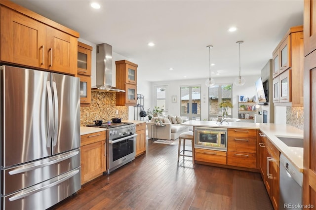 1511 S Pennsylvania St, Denver, CO 80210 - kitchen with stainless steel appliances, wall chimney exhaust hood, glass insert cabinets, a peninsula, and a kitchen bar