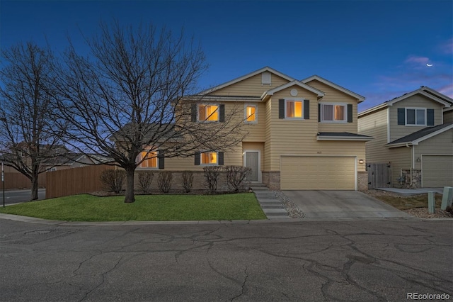 view of front of property featuring a front lawn, driveway, fence, an attached garage, and brick siding