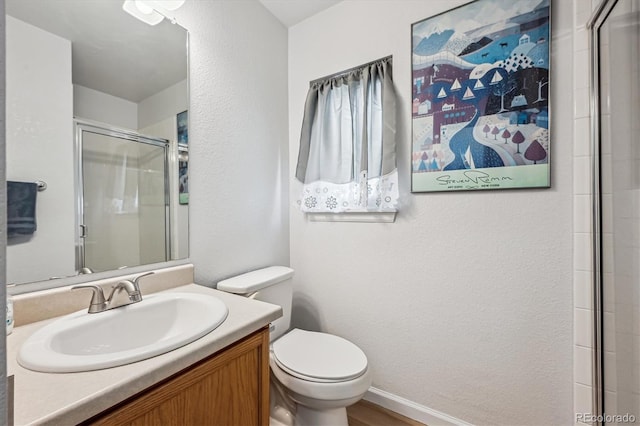 bathroom with an enclosed shower, toilet, vanity, and a textured wall