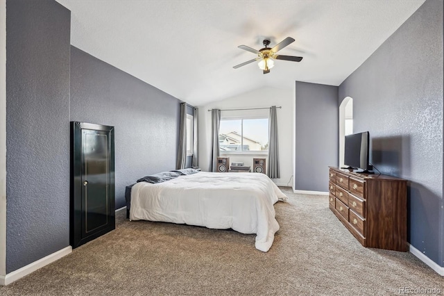 bedroom with vaulted ceiling, baseboards, carpet, and a textured wall