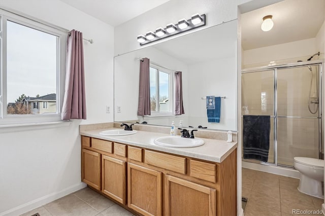 full bath with tile patterned flooring, a shower stall, and a sink