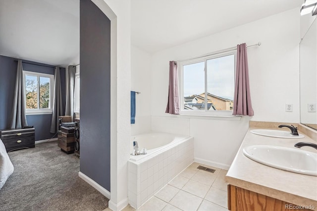 bathroom featuring tile patterned floors, a garden tub, visible vents, and a sink